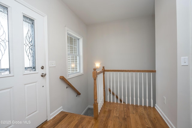 foyer featuring baseboards and wood finished floors