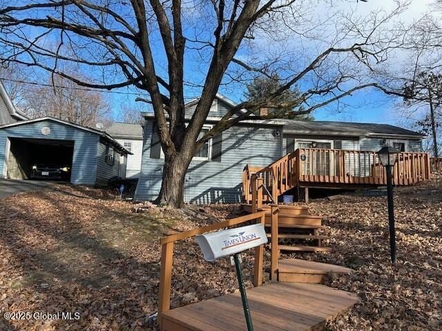 exterior space featuring a garage, an outdoor structure, and a deck