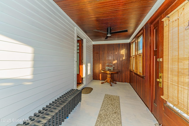 hallway featuring crown molding, wooden walls, and wooden ceiling