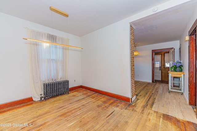 unfurnished room with hardwood / wood-style flooring and radiator heating unit