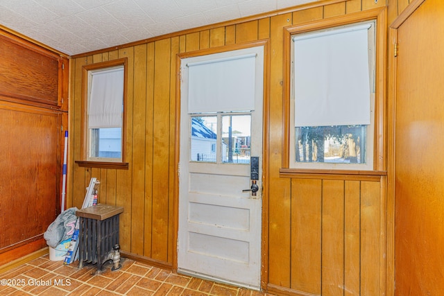 doorway to outside featuring wood walls