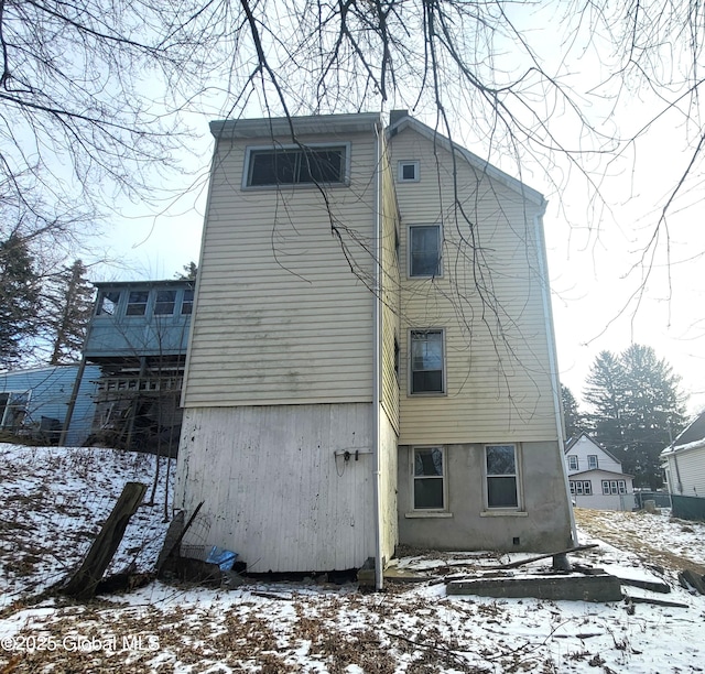 view of snow covered back of property