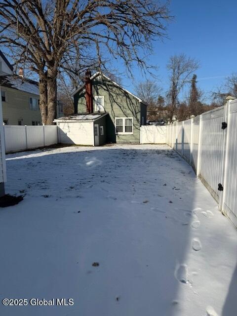 snowy yard featuring a shed