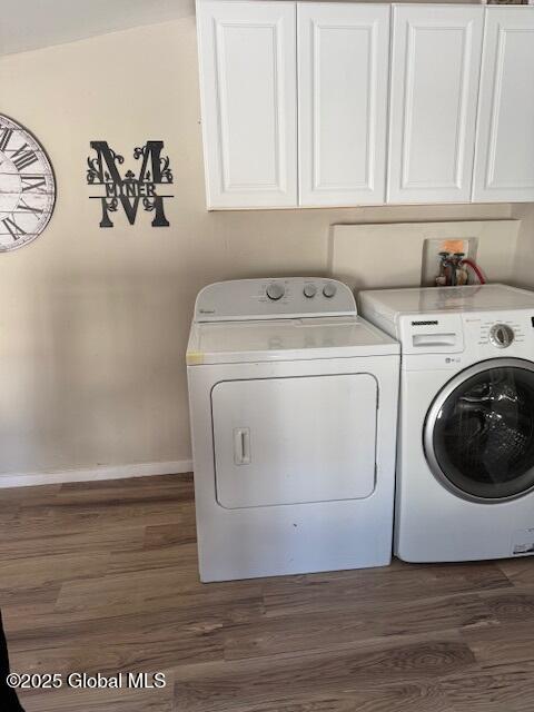 washroom featuring dark hardwood / wood-style flooring, washer and clothes dryer, and cabinets