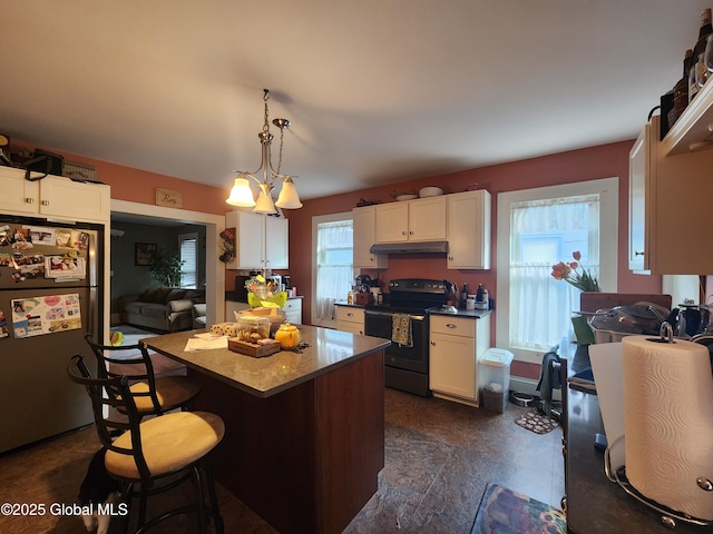 kitchen featuring white cabinets, a kitchen island, decorative light fixtures, black range with electric cooktop, and stainless steel refrigerator