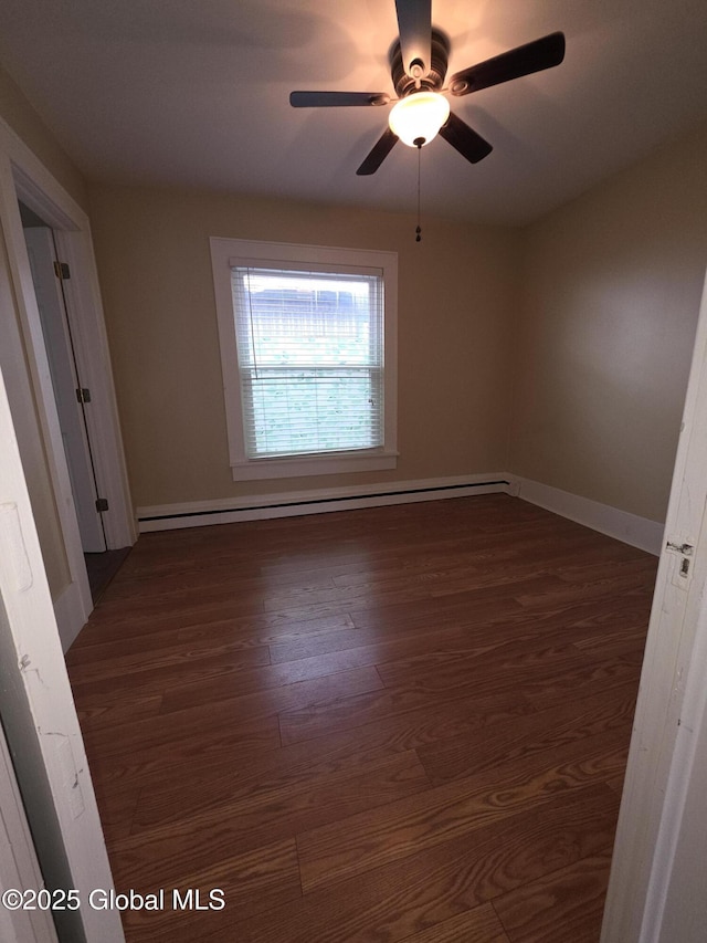 empty room featuring dark wood-type flooring, a baseboard radiator, and ceiling fan