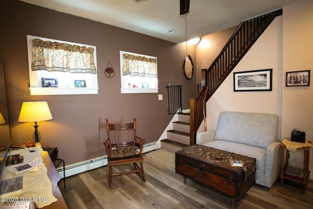 sitting room with a baseboard heating unit and hardwood / wood-style flooring