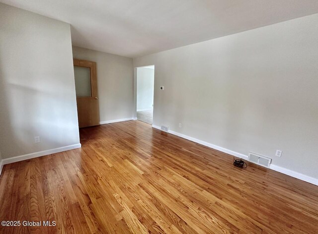 spare room with baseboards, visible vents, and light wood-type flooring