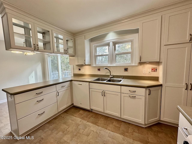 kitchen featuring decorative backsplash, dishwasher, a peninsula, and a sink