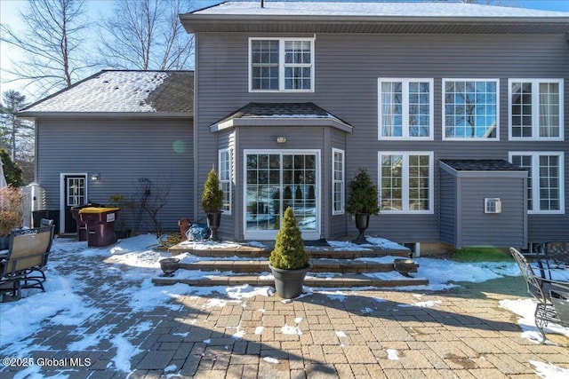 snow covered property with a patio