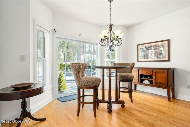 dining area featuring light hardwood / wood-style floors and a notable chandelier