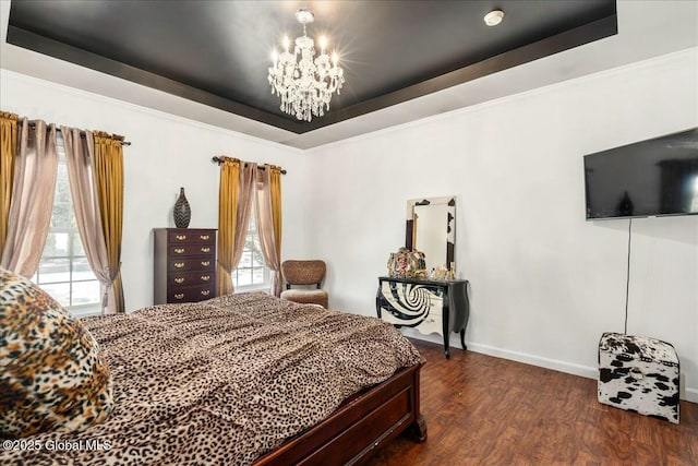 bedroom featuring an inviting chandelier, a tray ceiling, and dark wood-type flooring