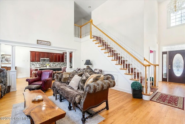 living room with light hardwood / wood-style flooring and a high ceiling