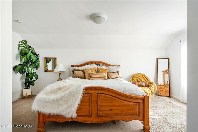 bedroom with lofted ceiling and light colored carpet