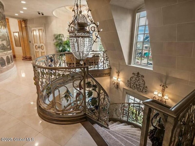 stairway with recessed lighting, plenty of natural light, tile walls, and tile patterned floors