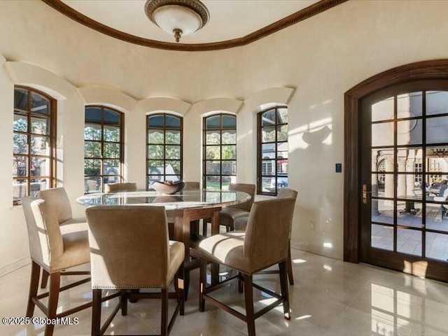 dining space featuring baseboards and crown molding