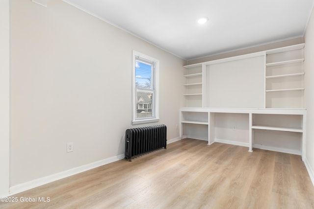 interior space with radiator heating unit, baseboards, and light wood finished floors