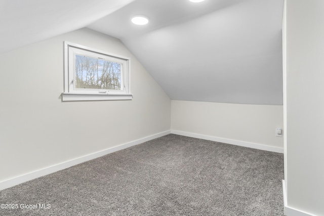 additional living space featuring baseboards, carpet flooring, and vaulted ceiling