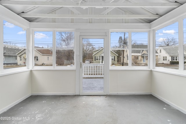 unfurnished sunroom featuring vaulted ceiling and a healthy amount of sunlight