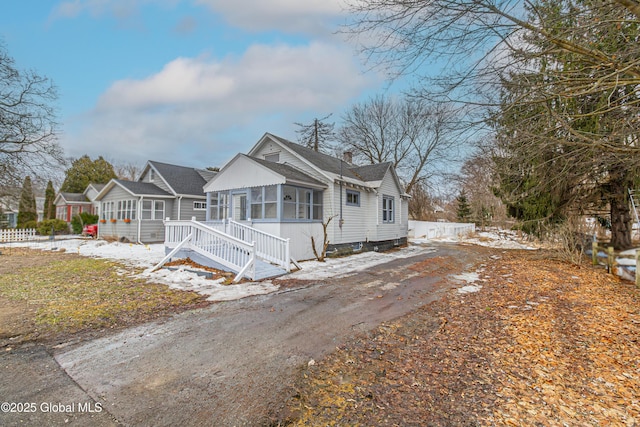 bungalow with a sunroom and a chimney