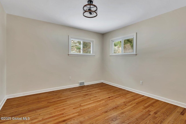 spare room with visible vents, light wood-style flooring, and baseboards