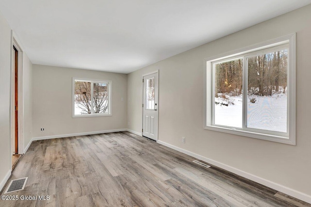 interior space with visible vents, wood finished floors, and baseboards