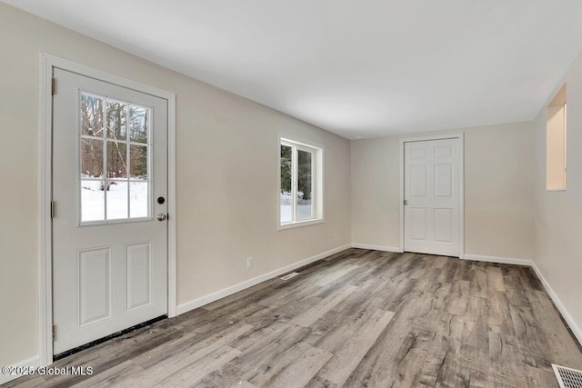 foyer featuring visible vents, baseboards, and wood finished floors