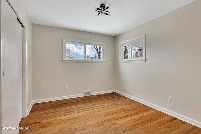 unfurnished bedroom with light wood finished floors, visible vents, baseboards, and a closet