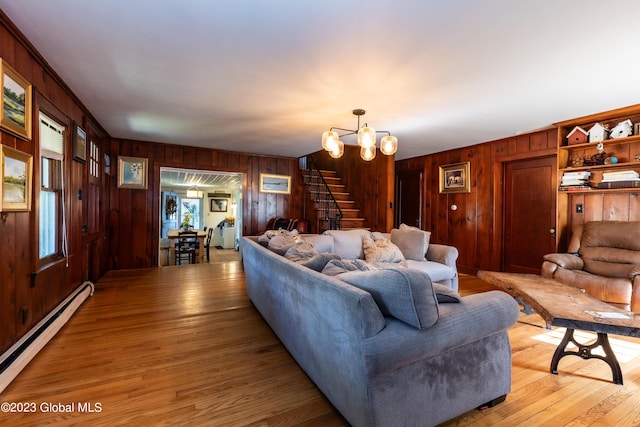 living room featuring an inviting chandelier, a baseboard radiator, light hardwood / wood-style flooring, and wood walls