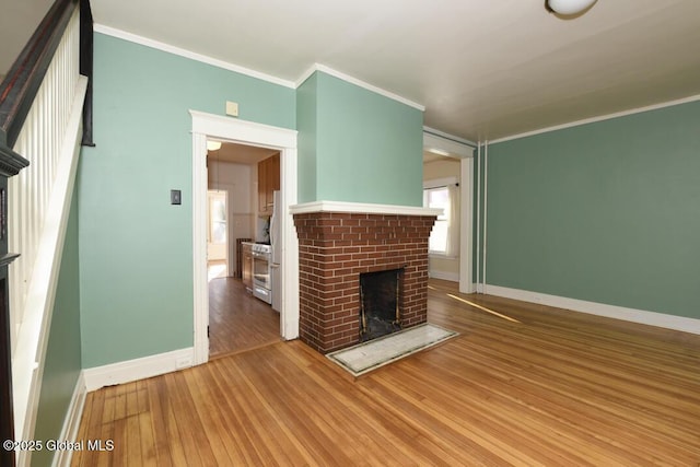 unfurnished living room featuring ornamental molding, wood-type flooring, and a fireplace