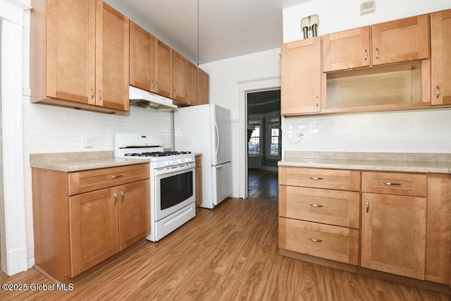 kitchen with tasteful backsplash, light wood-type flooring, and white appliances