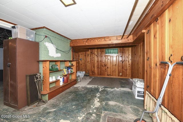 bonus room with wooden walls and concrete flooring