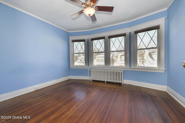 empty room featuring ceiling fan, ornamental molding, radiator heating unit, and dark hardwood / wood-style floors