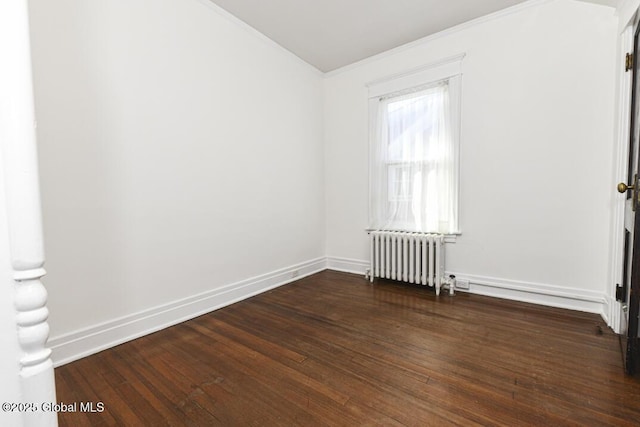 spare room with radiator heating unit and dark hardwood / wood-style flooring