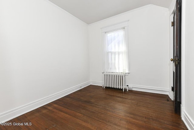 spare room featuring dark hardwood / wood-style flooring and radiator heating unit