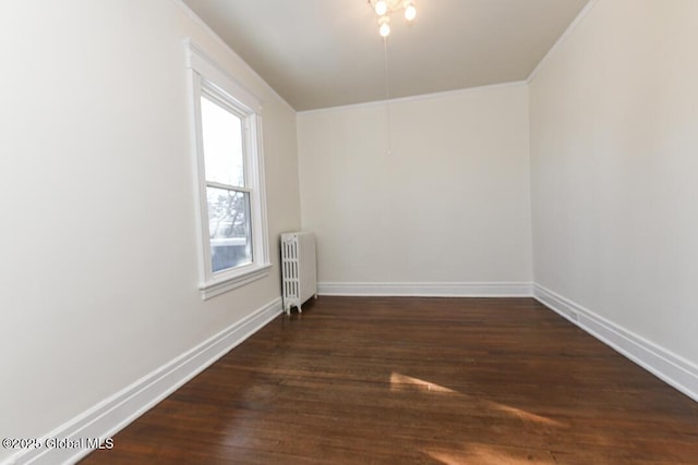 empty room featuring dark wood-type flooring and radiator heating unit