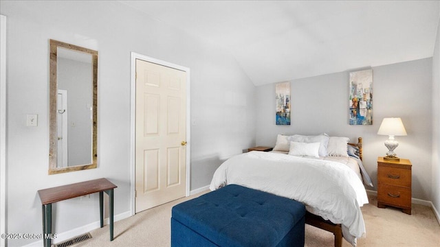 bedroom with light colored carpet and vaulted ceiling