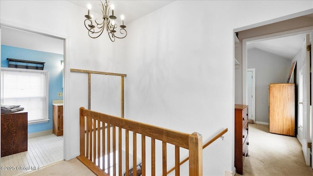 hallway featuring vaulted ceiling, light carpet, and a notable chandelier