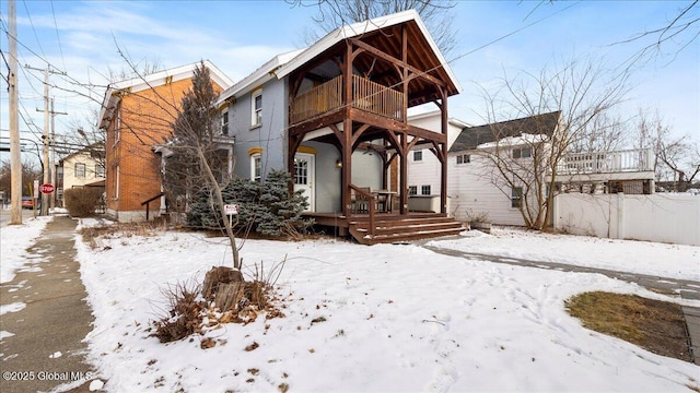 snow covered rear of property featuring a balcony