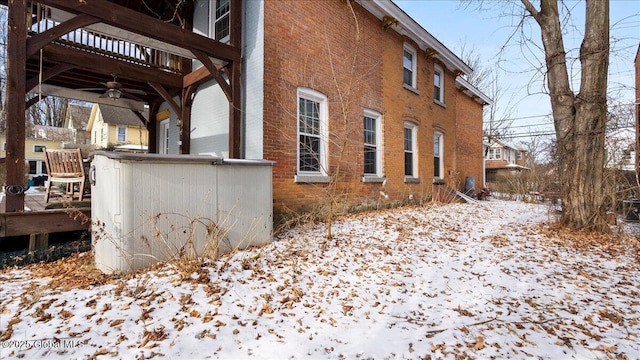 snow covered property featuring ceiling fan