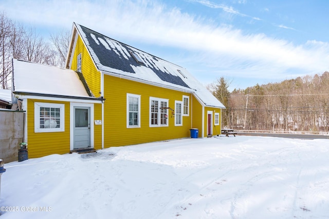 view of snow covered rear of property