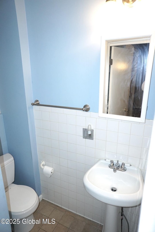 bathroom featuring sink, tile walls, tile patterned floors, and toilet