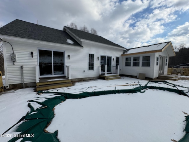 view of snow covered rear of property