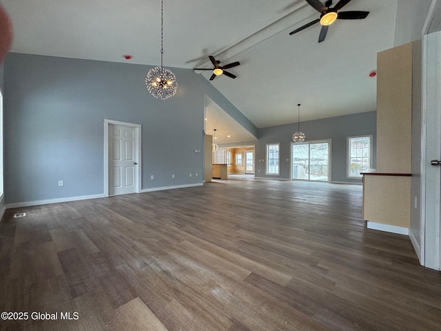 unfurnished living room with dark hardwood / wood-style floors, ceiling fan with notable chandelier, and high vaulted ceiling