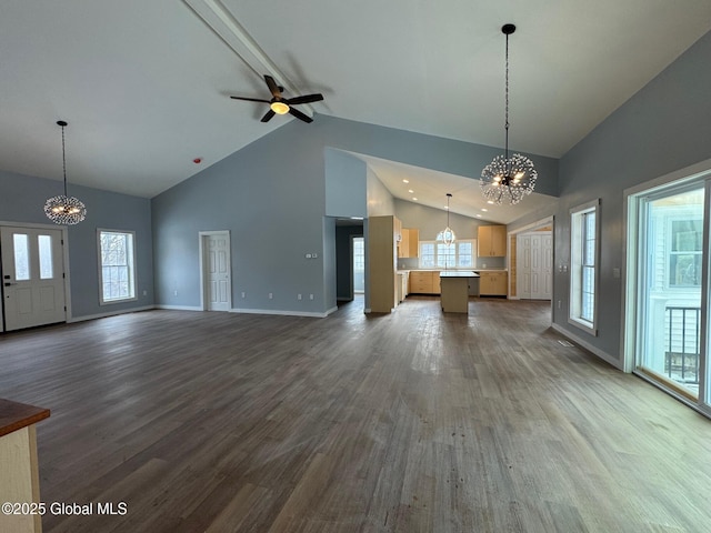 unfurnished living room with wood-type flooring, plenty of natural light, ceiling fan with notable chandelier, and high vaulted ceiling