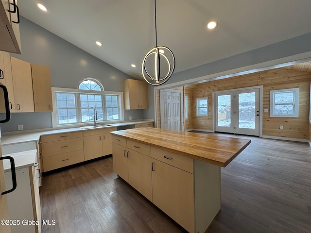 kitchen featuring sink, dark wood-type flooring, a kitchen island, wood counters, and decorative light fixtures