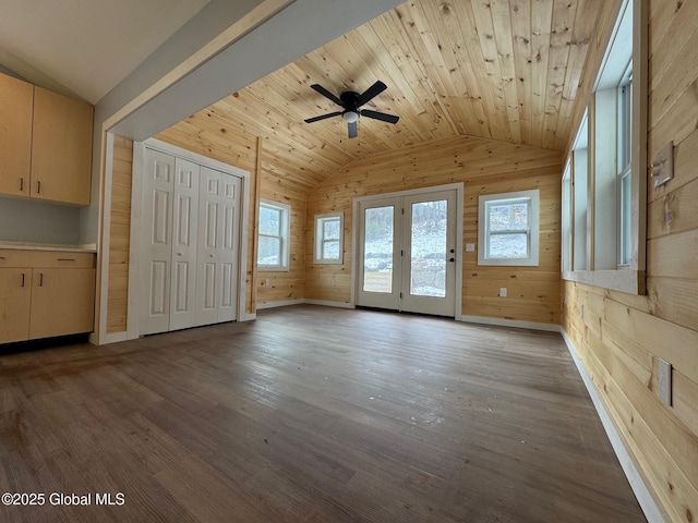 unfurnished living room featuring light wood-type flooring, wooden walls, vaulted ceiling, and wooden ceiling