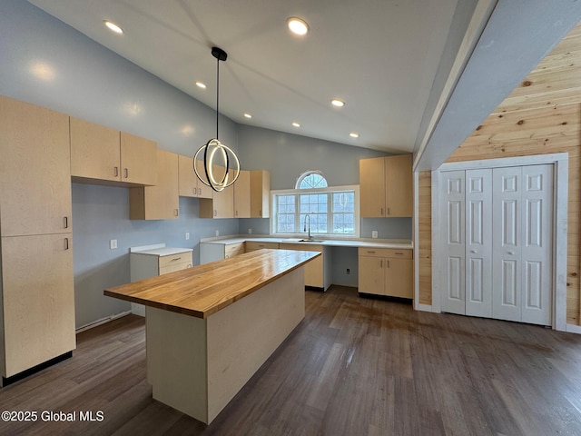 kitchen featuring a kitchen island, high vaulted ceiling, butcher block countertops, decorative light fixtures, and light brown cabinets