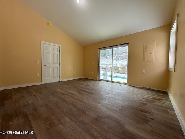 spare room featuring dark wood-type flooring, high vaulted ceiling, and electric panel