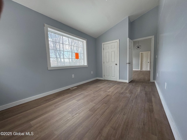 unfurnished bedroom featuring lofted ceiling and hardwood / wood-style floors